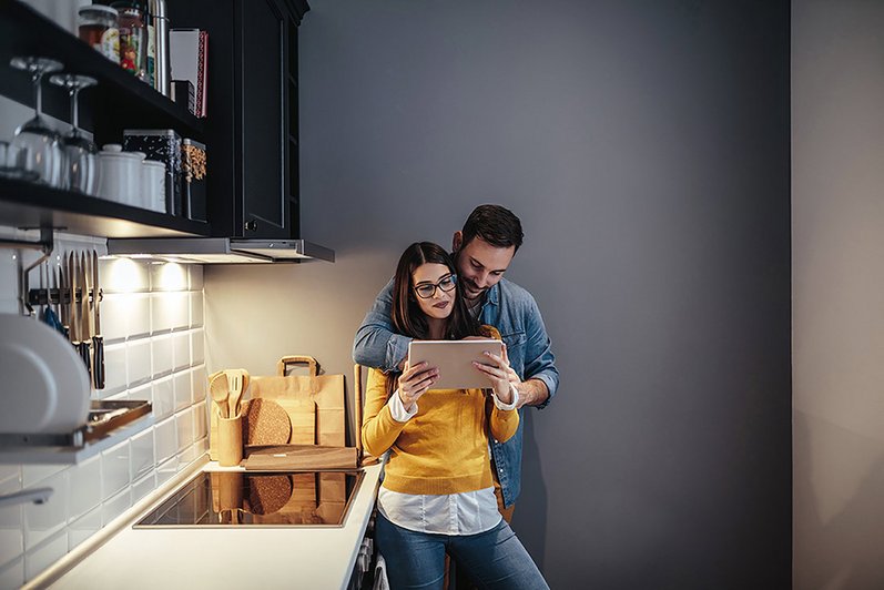 jeune couple dans une cuisine aménagée sur une tablette